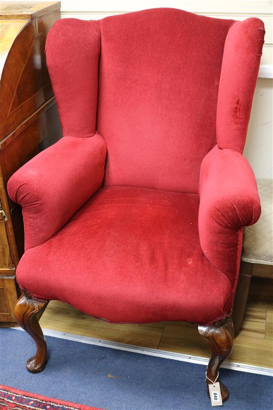 A Queen Anne style upholstered wing armchair on walnut cabriole legs